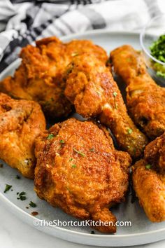 fried chicken on a white plate with a side of broccoli and parsley