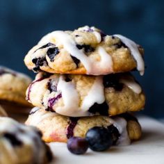 three blueberry cookies stacked on top of each other with icing drizzle