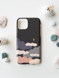 a phone case sitting on top of a white table next to rocks and sea shells