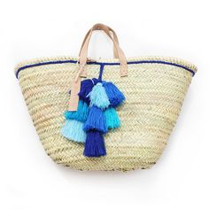 a straw bag with tassels and leather handles