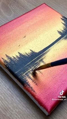 a pink and blue notebook with a pencil in it sitting on a table next to a pen