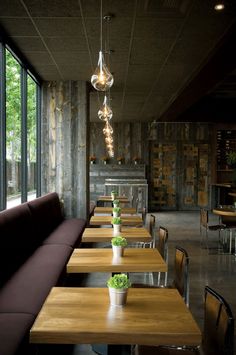 a restaurant with wooden tables and purple couches in front of large windows that look out onto the outdoors