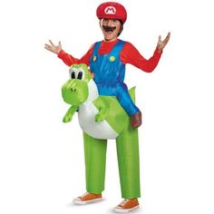 an adult inflatable costume riding on top of a green dinosaur with his arms out