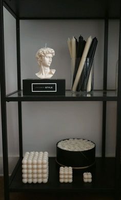 a shelf with candles and a busturine on it