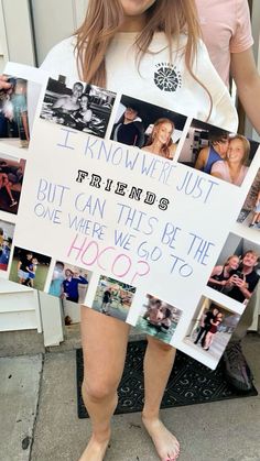 a woman holding up a sign with photos on it