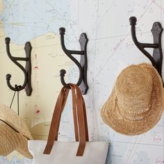 two hats are hanging on the wall next to a purse and hat rack with hooks