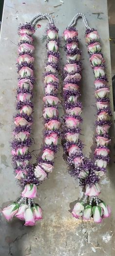 three pink and white flowers sitting on top of a metal table next to each other