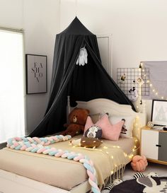 a child's bedroom decorated in black, white and pastel pink with a teepee tent