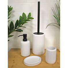 three white bathroom accessories sitting on top of a wooden table