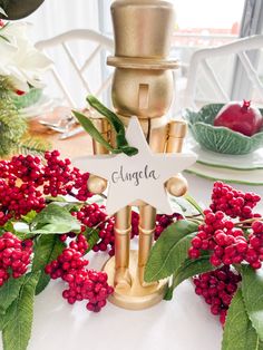 a star decoration on top of a table with red berries and greenery around it