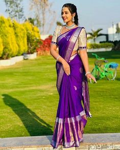 a woman in a purple sari posing for the camera