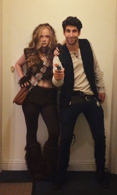 two people dressed in costumes posing for a photo with one holding a bottle and the other standing up