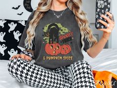 The perfect fall vibes tee for this upcoming fall! Gift this colorful Halloween tee to the cat lover friends of yours! T-shirt description: A woman wearing a cute, vintage Comfort Colors T-shirt with the text Spooky Vibes & Pumpkin Spice in orange and black font. There is a black cat standing on an orange carved pumpkin and surrounded by green mist and twinkling stars.  Unfortunately, at this time, we do not offer specialty gift wrapping. How to Order: 1) Check our photos for the size guide and Spooky Cat Design T-shirt For Fall, Spookie Season, Cat Standing, Get Happy, Spooky Vibes, Comfort Colors Shirt, Birthday Wishlist, Halloween Tees, Lovers And Friends