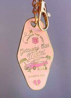 a pink keychain hanging from a metal hook on a purple background with the words giveaway car motel