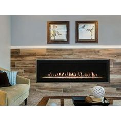 a living room with a fire place in the center and two framed pictures on the wall