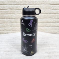 a black water bottle with the words demonia written on it