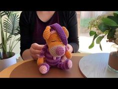 a woman sitting at a table holding a stuffed animal