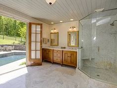 a large bathroom with a walk in shower next to a swimming pool