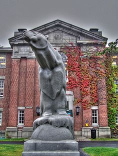 a statue in front of a building with ivy growing on it