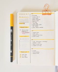 an open notebook with a yellow marker next to it on top of a white table