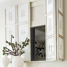 a vase with some flowers in it sitting on a shelf next to a mirror and mail boxes