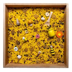 a wooden frame filled with lots of different types of food and decorations on top of yellow noodles