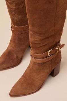 All your most exceptionally stylish fall looks are definitely going to include the Dolce Vita Tyrone Wide Calf Brown Suede Buckle Pointed-Toe Knee-High Boots! These genuine suede leather boots have a chic pointed-toe upper that rises to a 14"" knee-high with a 16.75"" circumference, an elastic gusset at the instep, and a curved topline. 8.5"" zipper at the instep. An adjustable buckle strap wraps around the ankle for a unique finishing touch! 3. 25" stacked block heel. Lightly cushioned insole. Rubber sole has nonskid markings. Genuine Suede Leather Upper. Man Made Materials. Imported. Lulus | Tyrone Wide Calf Brown Suede Buckle Pointed-Toe Knee-High High Heel Boots | Size 9.5WC. Suede Leather Boots, Wide Calf, Heel Boots, Fall Looks, High Heel Boots, Brown Suede, Suede Boots, High Boots, Knee High Boots