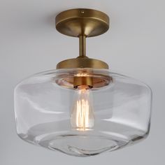 an image of a light fixture that is on the ceiling with clear glass and brass fixtures