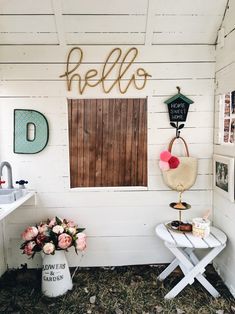 there is a sign that says hello on the wall and some flowers next to it