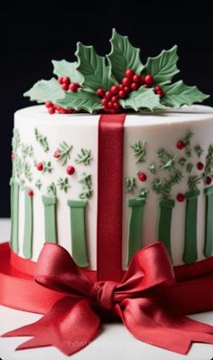 a christmas cake decorated with holly and red ribbon