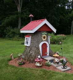 a small tree house with a red roof and white trimmings on the door