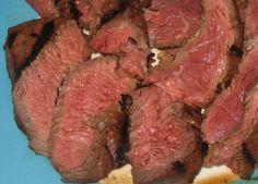 sliced meat on a blue plate sitting on a table