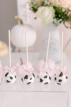 four cake pops decorated with black and white polka dots