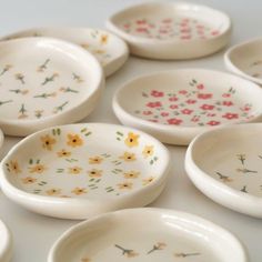 many small bowls with flowers painted on them