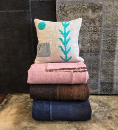 a stack of towels and pillows on top of each other in front of a wall