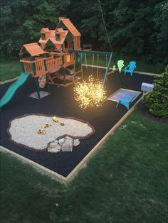 a backyard with a swing set, fire pit and play area in the middle of it