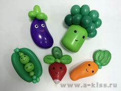 four plastic vegetables with faces on them sitting next to each other in front of a white background