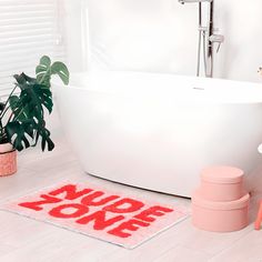 a white bath tub sitting next to a plant