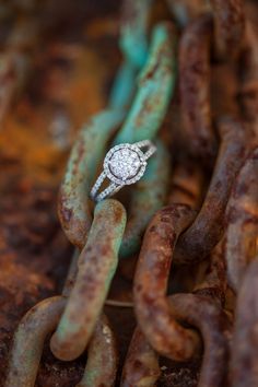 a diamond ring sitting on top of a chain in the middle of some rusted metal