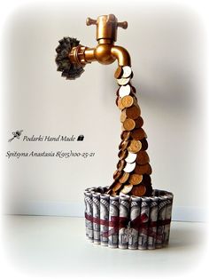 a toilet paper roll sculpture made to look like a stack of coins with a faucet on top