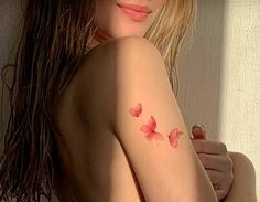 a woman with long hair and pink flowers on her arm