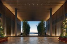 an empty lobby with columns and plants on either side