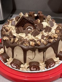 a cake with chocolate and marshmallows on it sitting on a red plate