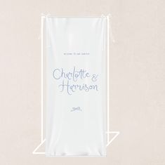 a white bag with the words charlotte and harrison on it sitting in front of a beige wall