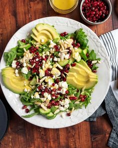 a salad with avocado, feta cheese and pomegranates