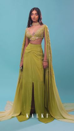 Citrus draped dhoti skirt with a crop top in long cape embroidered sleeves.
It is crafted in crepe with the slit at the bottom , side zip closure.
The crop top comes in cut dana, sequins, and beads floral and linear design motifs embroidery all over.
It comes in plunging V neckline and a curved hemline. Cape Top Lehenga, Cape Set Indian, Dhoti Crop Top, Blouse With Cape Sleeves, Cape Sleeve Lehenga, Drape Skirt And Top, Indian Outfits Modern Crop Tops, Dhoti Skirt With Crop Top, Long Cape Dress Indian