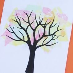 a tree made out of colored paper on an orange background