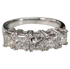 a three stone diamond ring with four stones on each side and two diamonds in the middle