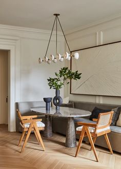 a living room filled with furniture and a large painting on the wall above it's table