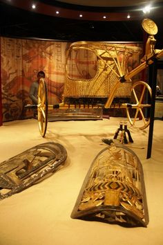 an exhibit with gold and silver items in it's display area, including a bench